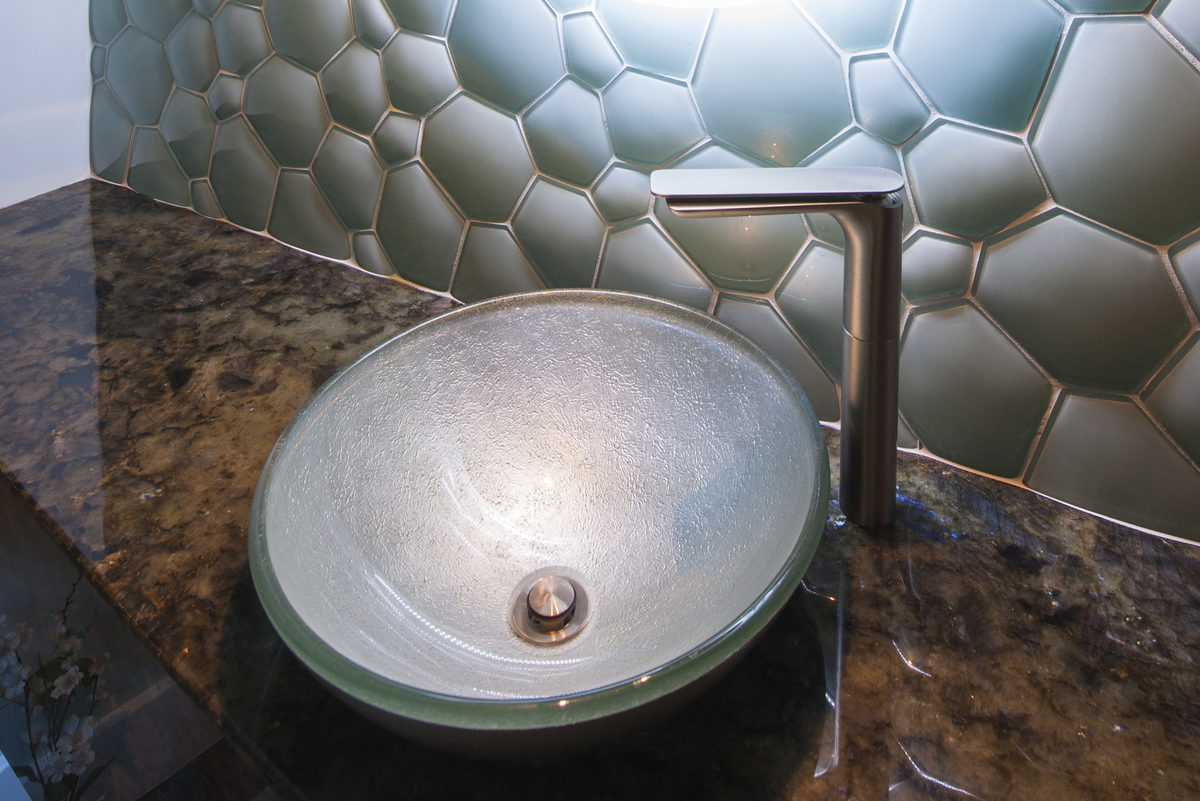 vessel sink rests on marble slab vanity top